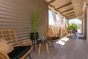 a room with chairs and a table with a plant at Vedi Town Luxury Apartment in Zakynthos