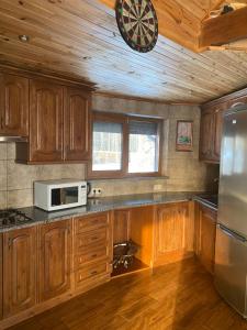 a kitchen with wooden cabinets and a clock on the ceiling at Диброва in Dibrova