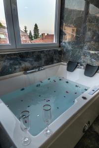 uma banheira com dois copos de vinho em RIBAR APARTMENTS em Ohrid