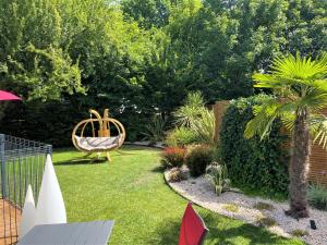 un jardín con banco y columpio en Hotel Restaurant Du Parc Saumur Logis Elégance en Saumur