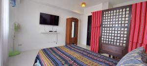 1 dormitorio con 1 cama y TV de pantalla plana en 6th Balcony en Baguio