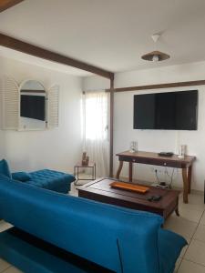a living room with a blue couch and a flat screen tv at Love Guadeloupe in Sainte-Anne