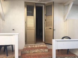 a door to a house with a table and a bench at Hotel Giglio in Lampedusa