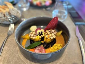 un tazón de comida sentado en una mesa en Hotel Restaurant Du Parc Saumur Logis Elégance, en Saumur