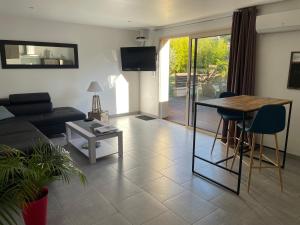 a living room with a couch and a table at Villa COSA Spa privatif, Gîte proche Sarlat in Vitrac