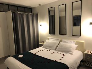 a bedroom with a bed with white sheets and pillows at Villa COSA Spa privatif, Gîte proche Sarlat in Vitrac