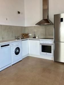 a kitchen with white appliances and a refrigerator at Villa Calma in Cala en Bosc