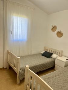 a bedroom with two twin beds and a window at Villa Calma in Cala en Bosc