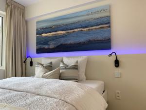een slaapkamer met een schilderij boven een bed bij DE HORLOGE luxueus vakantie appartement in Oostende