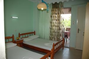 a bedroom with two beds and a door to a patio at VILLA STATHIS in Nea Vrasna