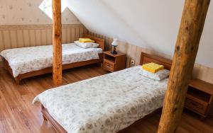 two twin beds in a room with wooden floors at Nurmeveski Guesthouse in Nurme