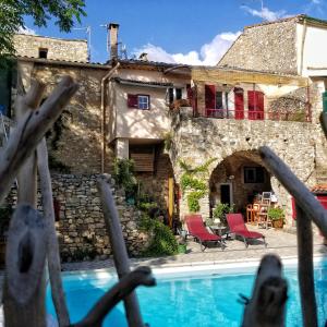 a house with a swimming pool in front of a building at La Dolce Vita - Chambre Cristoforo Colombo in Montpeyroux