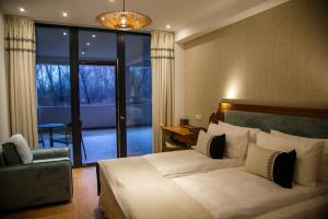 a bedroom with a bed and a chair and a window at New Egreta Resort in Dunavăţu de Jos +56 photos