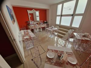 comedor con mesas, sillas y espejo en Corallo Rosso B&B, en Terrasini