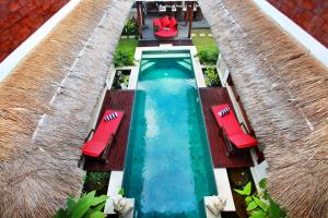 een uitzicht over een zwembad met rode stoelen bij Villa Bukit Nusa Lembongan in Nusa Lembongan +57 foto's