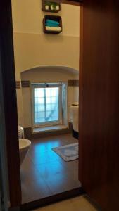 a bathroom with a toilet and a window at Nial House in Monopoli