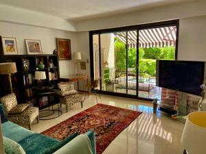 a living room with a tv and a large window at Un Coin de Paradis in Cannes