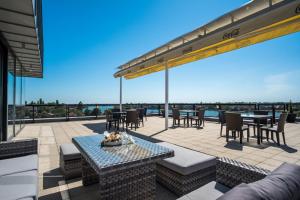 a patio with tables and chairs and a view of the ocean at Hotel Dolphin in Senec