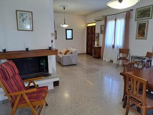 uma sala de estar com uma televisão e uma mesa e cadeiras em Da Zio Mario em Flumini di Quartu