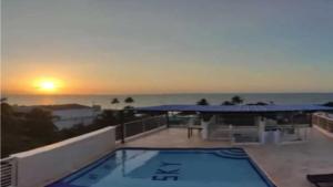 a swimming pool on a balcony with the sunset at Sky view hotel tolu in Tolú