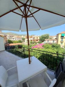 a white table with an umbrella on a balcony at Cialoma Full Green in Marina di Camerota