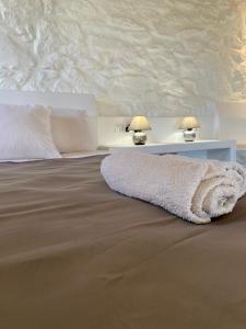 Una cama con una manta blanca y dos lámparas. en My Oasis Studios Mykonos, en Klouvas