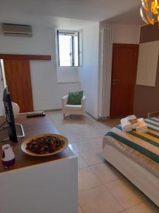 a room with a bed and a table with a plate of food at Nial House in Monopoli