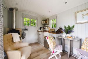 a kitchen and living room with a couch and a table at Red Deer Escape in Wheddon Cross