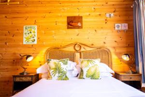 een slaapkamer met een wit bed en houten wanden bij Tolcarne Beach Cabins in Newquay