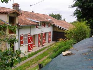 ein weißes Haus mit roten Fenstern und einer Garage in der Unterkunft Maison spacieuse à Camarade avec grand jardin pour 15 personnes in Durban-sur-Arize