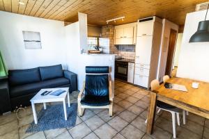 a living room with a couch and a table and a kitchen at 2-Zimmerwohnung an zentraler Lage/Ski-in, Ski-out in Riederalp