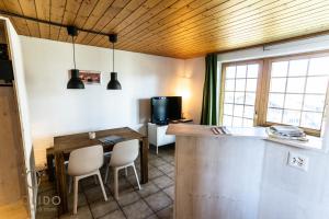 a kitchen with a table and chairs and a television at 2-Zimmerwohnung an zentraler Lage/Ski-in, Ski-out in Riederalp