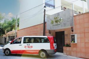 een wit en rood busje geparkeerd voor een gebouw bij Hotel Boutique La Rioja in Atlixco