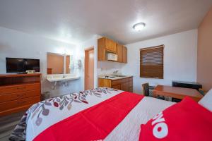 馬德拉斯的住宿－Budget Inn Madras by OYO，卧室配有红色和白色的床和书桌。