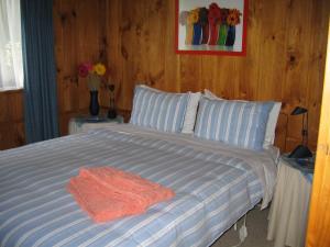 a bedroom with a large bed with blue and white stripes at Rapaura Watergardens in Tapu