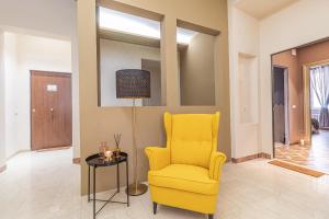 salon z żółtym krzesłem i stołem w obiekcie Galvani Apartments w mieście Terni