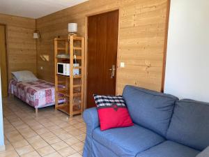 a living room with a blue couch with a red pillow at La Saume in Ceillac