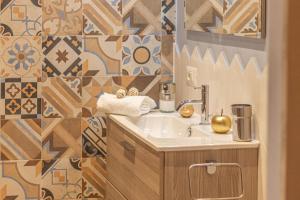 a bathroom with a sink and a tiled wall at Galvani Apartments in Terni