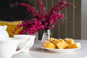 a table with two cups and a plate of bread at Hooting Owl Retreat in Wheddon Cross