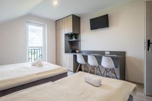 a bedroom with two beds and a bar with a balcony at Jakubowa Polana - pokoje in Łeba