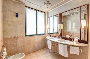 baño con 2 lavabos y espejo grande en Dreamhotel, en Appiano Gentile