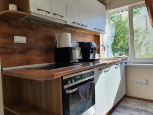 uma cozinha com armários brancos e um forno com placa de fogão em Malavi KI top center studio Ruse em Ruse