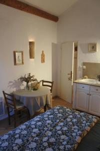 une chambre avec une table et une cuisine avec un évier dans l'établissement Les Mazets de Pascale, à Saint-Rémy-de-Provence