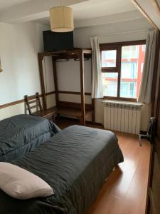 Un dormitorio con dos camas y una ventana en Hosteria Sloggett, en Ushuaia