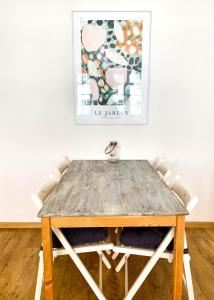 een houten tafel met stoelen en een schilderij aan de muur bij Old Town Apartment in Gdańsk