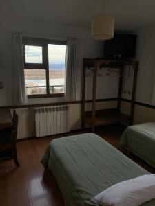 a bedroom with two beds and a large window at Hosteria Sloggett in Ushuaia