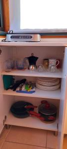 a kitchen shelf with dishes and plates and a stove at La Piana degli Ulivi in Rossano