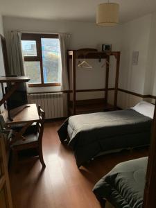 1 dormitorio con 2 camas y ventana en Hosteria Sloggett en Ushuaia