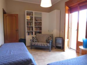 a bedroom with a bed and a chair and a tv at Casa il Giovane Alloro in Martina Franca