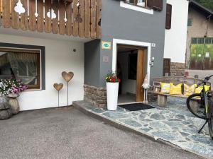 a house with a patio with a bench and flowers at Garni Monika in Canazei